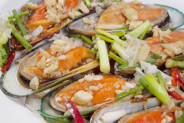 Kabuklu deniz ürünleri midyeyeni Zelanda beyaz arka plan üzerinde istiridye sosu ile karıştırın.