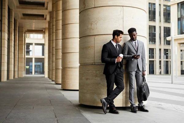 Dos Jóvenes Hombres Negocios Trajes Hablando Mientras Están Pie Cerca — Foto de Stock