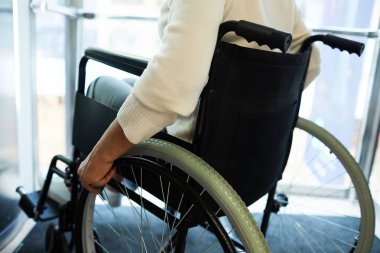 Asansörde tekerlekli sandalyede oturan engelli yaşlı kadın.