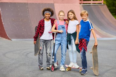Kaykay parkında günlük giysiler içinde kaykay sürmeye giden bir grup arkadaşın portresi.