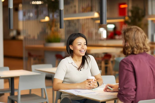 Gelukkige Jonge Vrouw Drinken Van Koffie Praten Met Jongeman Terwijl — Stockfoto