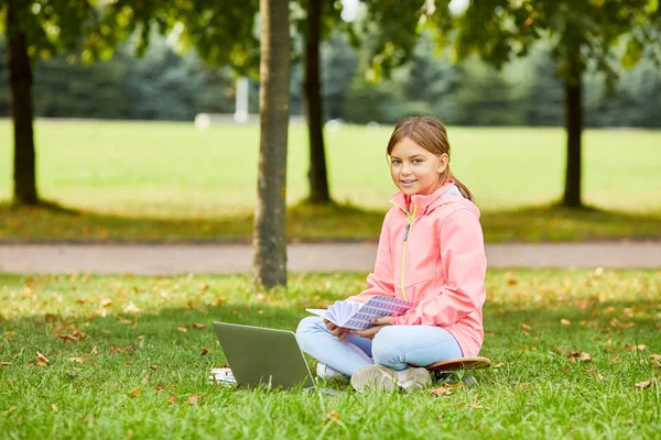 Portrait Écolière Mignonne Assise Sur Herbe Verte Souriant Caméra Tout — Photo