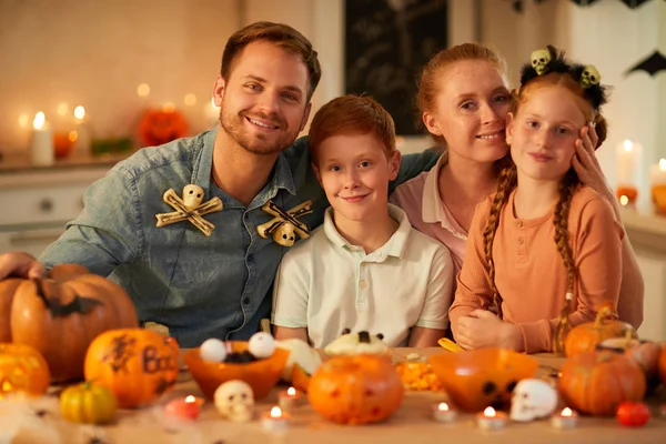 Glad Familj Med Fyra Sittande Vid Bordet Tillsammans Dekorera Pumpor — Stockfoto