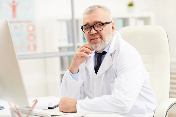 Portrait Successful Senior Doctor White Coat Smiling Camera While Sitting — Stock Photo, Image