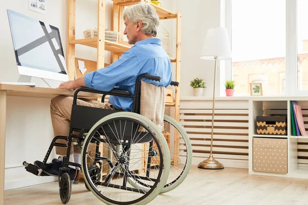 Niepełnosprawny Starszy Mężczyzna Siwymi Włosami Siedzący Wózku Inwalidzkim Patrzący Monitor — Zdjęcie stockowe