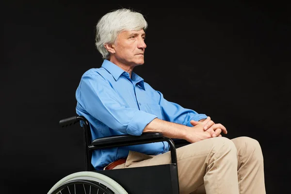 Старший Инвалид Сидящий Инвалидной Коляске Выглядящий Серьезно Черном Фоне — стоковое фото