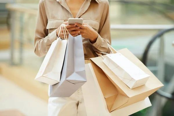 Närbild Ung Kvinna Som Håller Papperspåsar Och Kommunicera Online Mobiltelefon — Stockfoto