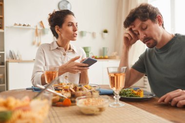 Kadın yemek sırasında erkekle konuşuyor.