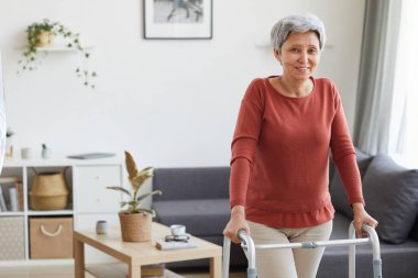 Yaşlı kadın evde Walker 'ı kullanıyor.