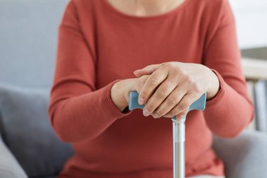 Koltuk değnekli yaşlı kadın.