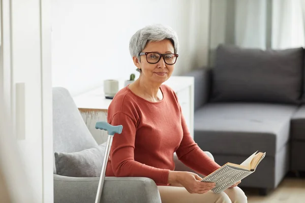 Frau ruht sich mit Buch zu Hause aus — Stockfoto