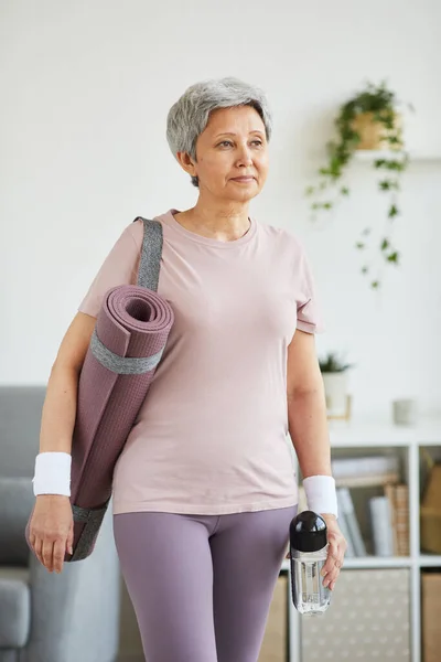 Evde spor yapan yaşlı bir kadın. — Stok fotoğraf