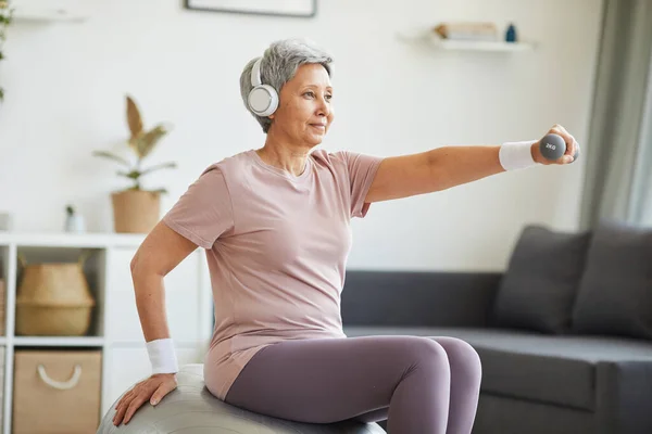 Oudere vrouw die thuis traint — Stockfoto