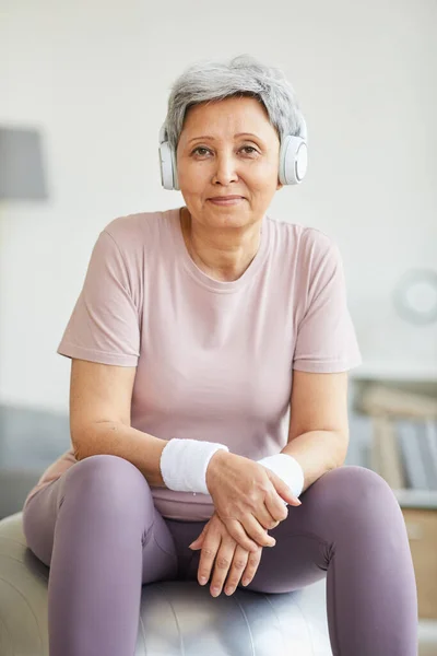 Mujer mayor sentada en una pelota de fitness — Foto de Stock