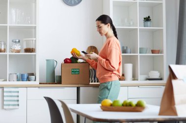 Kadın yemek dağıtımını kontrol ediyor.