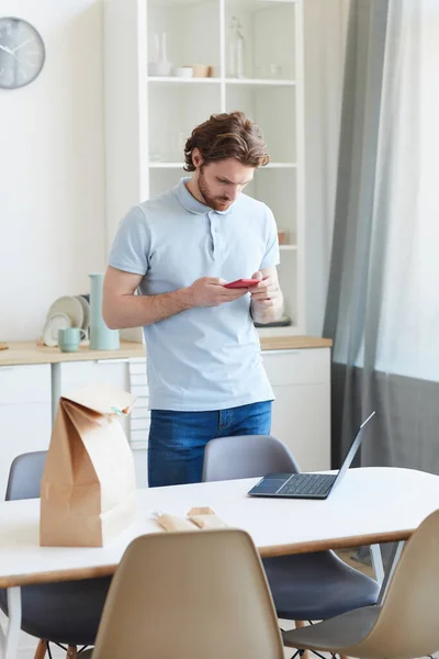 Homem usando telefone celular em casa — Fotografia de Stock