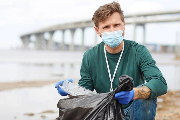 Доброволец кладет мусор в мешок — стоковое фото
