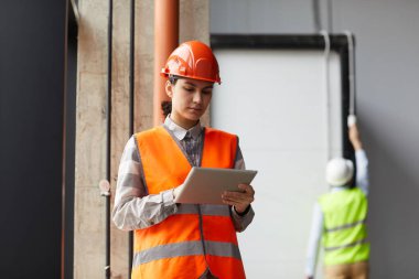 Tablet bilgisayar kullanan inşaat işçisi