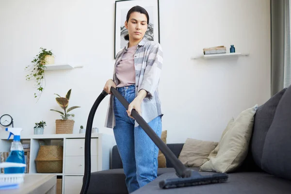 Mulher aspirando o sofá — Fotografia de Stock