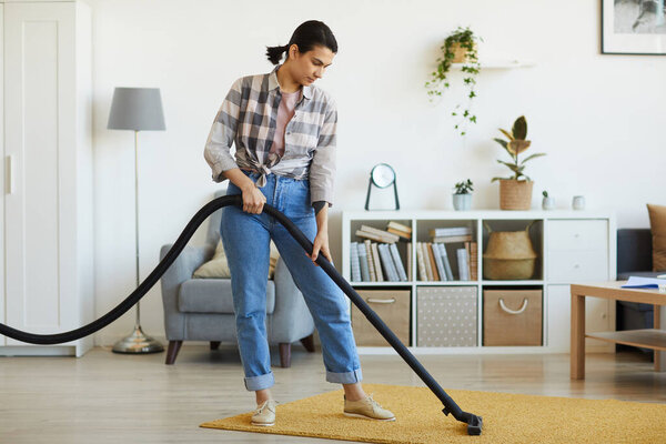 Housekeeper vacuuming the carpet