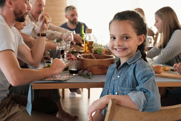 Маленькая девочка ужинает с семьей — стоковое фото