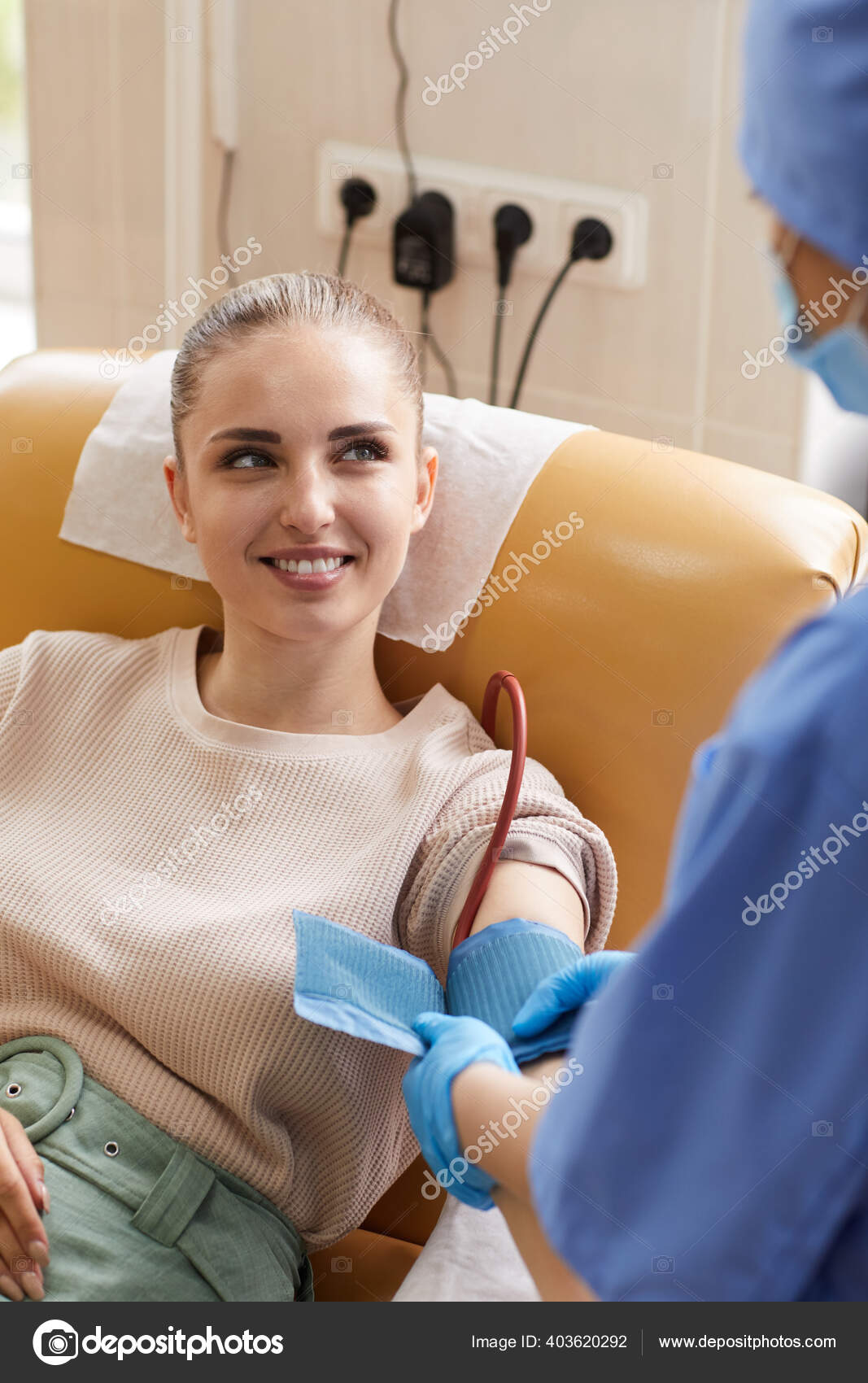 Young Woman Lying Couch Donating Blood While Smiling Nurse Stock Photo