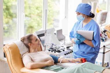 Hastanedeki hastanın koluyla kan tahlili yapan doktor.