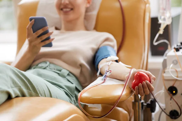 Close Jovem Deitada Sofá Com Telefone Celular Enquanto Doava Sangue — Fotografia de Stock