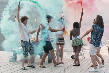 Rıhtımda dikilen ve renk festivali sırasında dans eden bir grup genç.