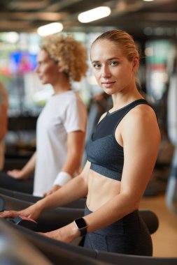 Koşu bandındaki genç kadın.