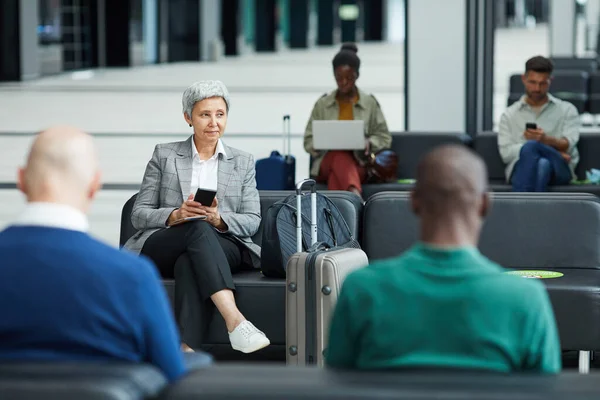 Pessoas sentadas no aeroporto — Fotografia de Stock