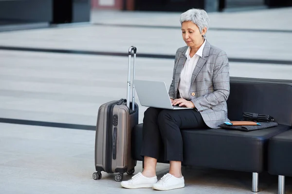 Woman using laptop at the airport — Stock Photo, Image