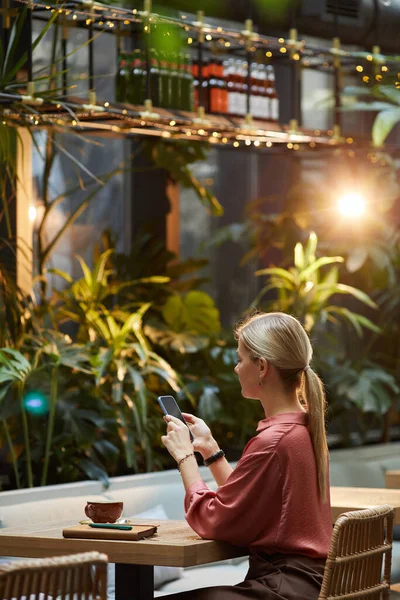 Жінка використовує телефон в кафе — стокове фото