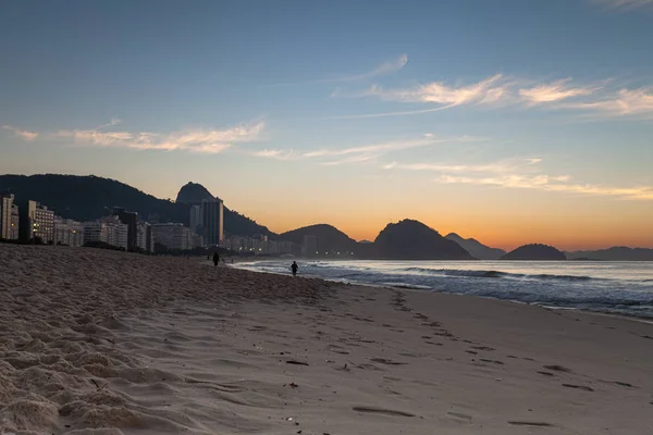 Tidal stages with the ocean waves of Copacabana beach in Rio de Janeiro with the Sugarloaf mountain in the background just before sunrise