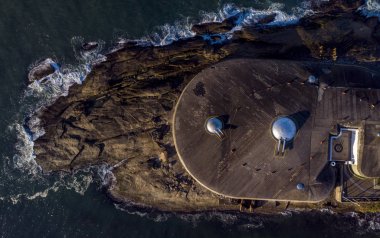Rio de Janeiro'daki Copacabana tarihi askeri fort ve müzesinin havadan görünümü, üzerine inşa edilen kayaya çarpan dalgalarla