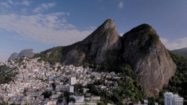 Onun dik tırmanış üzerinde Vidigal gecekondu ile Rio de Janeiro İki Brothers dağ tepesinde nanca. Yamaçlarda doğanın silueti manzara ve yamaçlarda yoğun kentsel gecekondu topluluk.