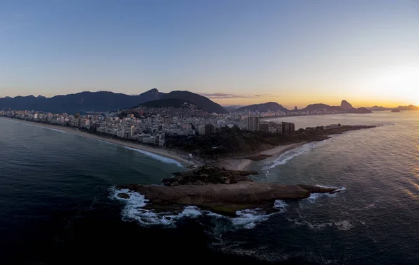 Arpoador, zıpkıncı, uçurum ve daha geniş şehir manzarası ve silueti ile Rio de Janeiro geniş hava panorama renkli bir gündoğumu gökyüzüne karşı arka planda
