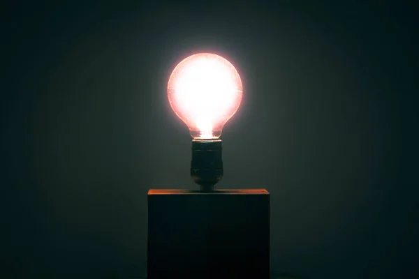 Lâmpada Solitária Uma Pequena Caixa Ligada Brilhando Uma Sombra Vermelha — Fotografia de Stock
