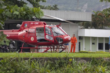 Rio de Janeiro, Brezilya - 20 Kasım 2015: Uçağın yanında duran bir kadın mürettebat üyesi ile itfaiye helikopteri
