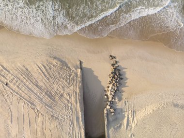 Kısmen inşa edilmiş ve kısmen yerleştirilmiş kayaların şehir gölüne giden bir kanal contrived ağız ile bozulmamış bir Leblon sahilde gelen dalgalar.