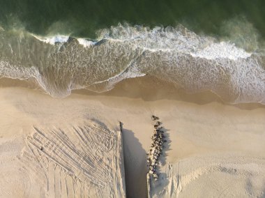 Kısmen inşa edilmiş ve kısmen yerleştirilmiş kayaların şehir gölüne giden bir kanal contrived ağız ile bozulmamış bir Leblon sahilde gelen dalgalar.