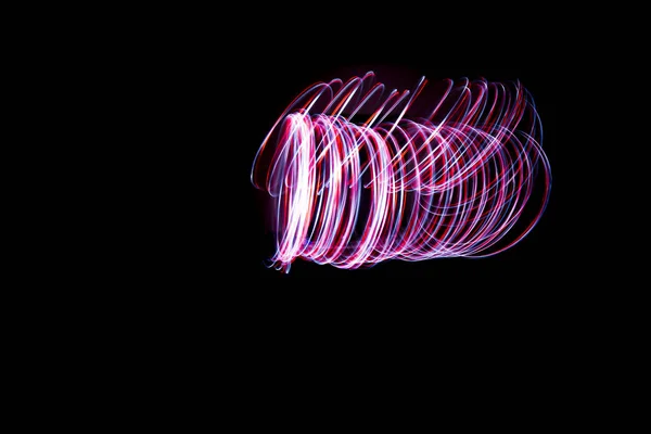 Light painting of continuous red and white spirals forming a double vortex like figure. Dynamic time trajectory of two lights simultaneously against a black background.