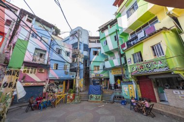 Rio de Janeiro, Brezilya - 30 Aralık 2014: Rio de Janeiro'daki favela Santa Marta'nın (Dona Marta) renkli ana meydanında bar masalarında dinlenen vatandaşlar var