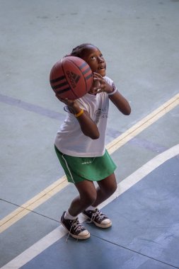 Rio de Janeiro, Brezilya-Ağustos 16, 2016: elinde basketbol ile genç kız konsantre ve diz bükülmüş topu atmak için hazır