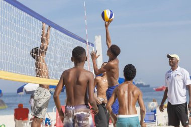Rio de Janeiro, Brezilya-Ağustos 16, 2016: plaj voleybolu bir oyunda adolesan çökertildi onun eşleri parlak güneşli bir gün üzerinde Copacabana plajında ona bakıyor