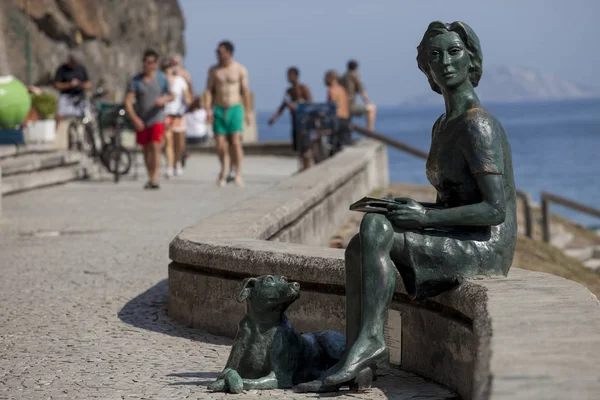 Rio de Janeiro, Brezilya-Ağustos 16, 2016: Boulevard sahil mahallede Copacabana Plajı ve Clarice Lispector bir heykel, bir köpek ile bir kadın, ön planda zevk