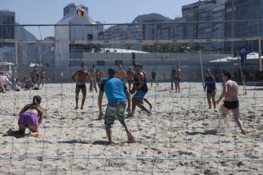 Rio de Janeiro, Brezilya-16 Ağustos 2016: parlak güneşli bir gün arka planda mahalle ile Copacabana plajında voleybol oynayan insanlar karışık Grup