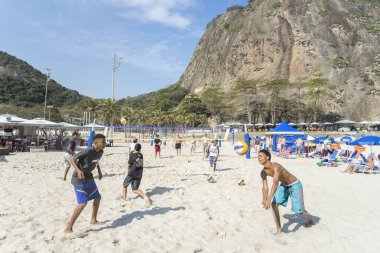 Rio de Janeiro, Brezilya-16 Ağustos 2016: parlak güneşli bir gün arka planda leme tepesi ile Copacabana plajında voleybol oynayan adolesan çocuklar