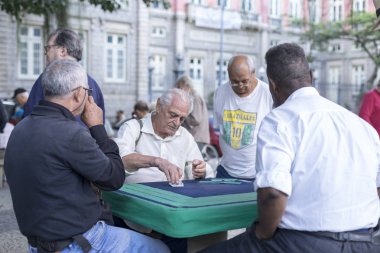 Rio de Janeiro, Brezilya - 28 Temmuz 2017: Yaşlılar yerel bir parkta toplanarak taş masalarda kart oyunları oynuyorlar. Yaşlı erkekler emeklilik zevk için bir meydanda sosyal toplama.