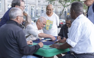 Rio de Janeiro, Brezilya - 28 Temmuz 2017: Yaşlılar yerel bir parkta toplanarak taş masalarda kart oyunları oynuyorlar. Yaşlı erkekler emeklilik zevk için bir meydanda sosyal toplama.